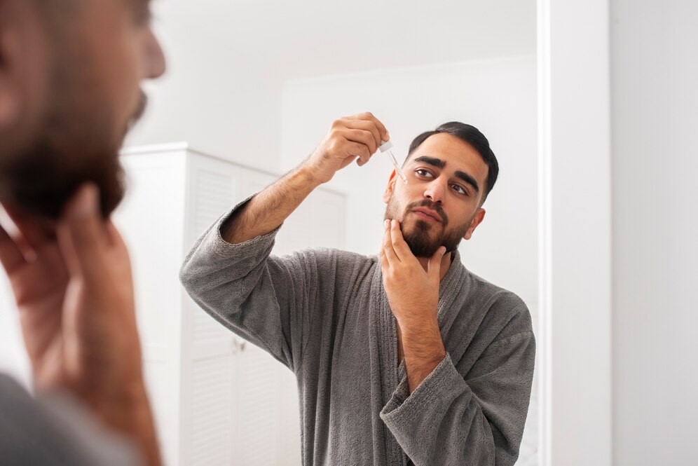 Homem mantendo sua barba saudável ao hidratar os fios e a pele. 